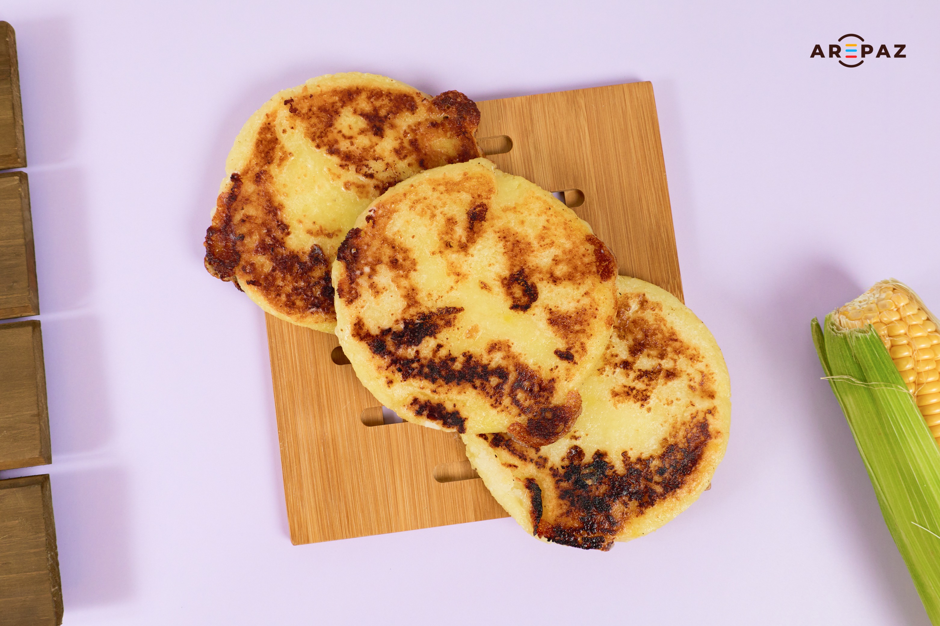 Traditional Colombian arepas on wooden board with corn